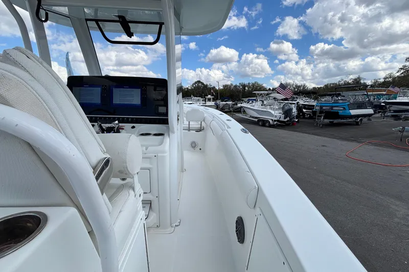 Slide: The Image of 2018 Sea Hunt Gamefish 30 boat interior with forward seating, docked under a cloudy sky. - 29