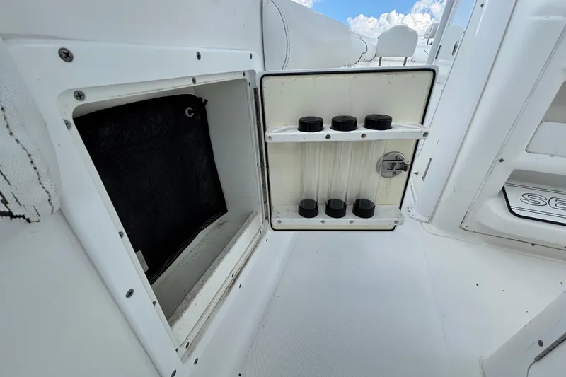 Slide: The Image of 2018 Sea Hunt Gamefish 30 storage compartment with rod holders, open on deck. - 32