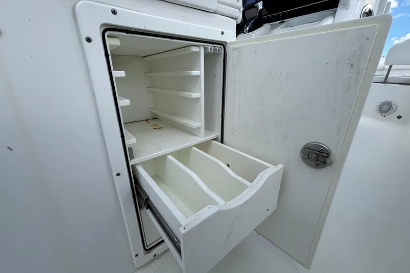 Slide: The Image of Open storage compartment on 2018 Sea Hunt Gamefish 30 boat, featuring shelves and drawers. - 37