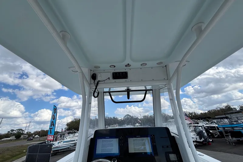Slide: The Image of 2018 Sea Hunt Gamefish 30 helm view with electronics, under a cloudy sky. - 42