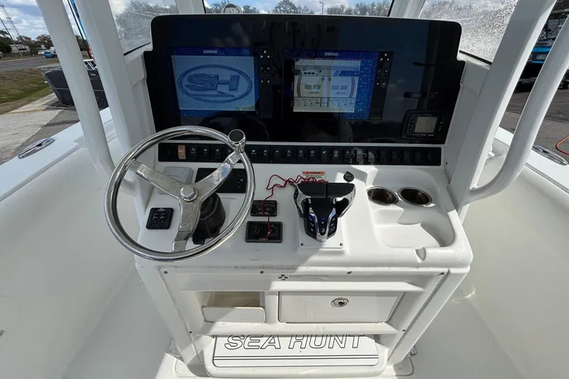 Slide: The Image of 2018 Sea Hunt Gamefish 30 helm with steering wheel, controls, and navigation display. - 44