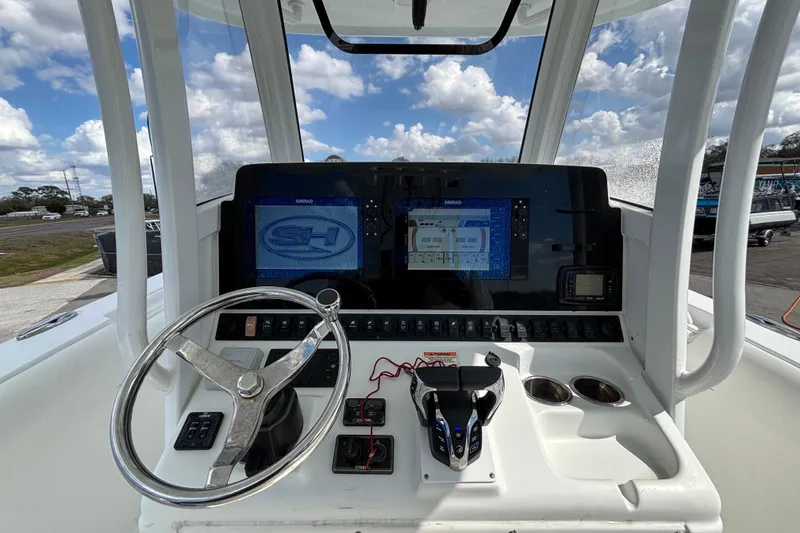 Slide: The Image of 2018 Sea Hunt Gamefish 30 dashboard with steering wheel and navigation screens. - 45