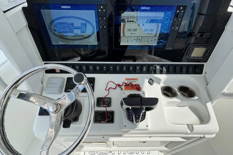 Slide: The Image of 2018 Sea Hunt Gamefish 30 dashboard with dual Simrad displays and steering wheel. - 47