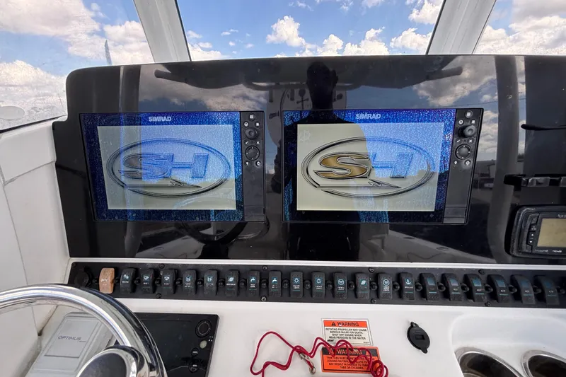 Slide: The Image of 2018 Sea Hunt Gamefish 30 dashboard with dual Simrad displays and control panel. - 49