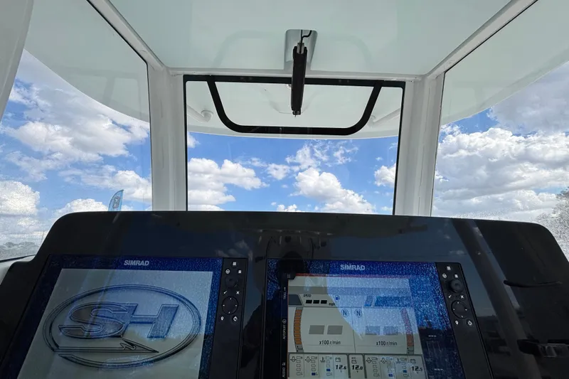 Slide: The Image of 2018 Sea Hunt Gamefish 30 dashboard with Simrad displays, clear sky view. - 52