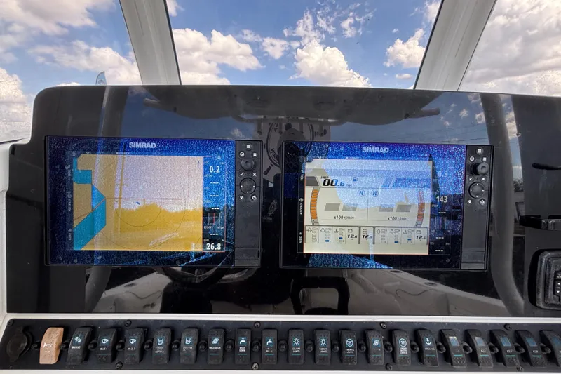 Slide: The Image of 2018 Sea Hunt Gamefish 30 dashboard with dual Simrad displays under a cloudy sky. - 61