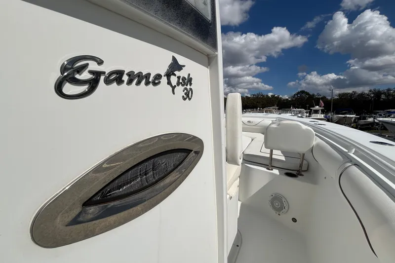 Slide: The Image of 2018 Sea Hunt Gamefish 30 boat with forward seating, under a partly cloudy sky. - 80