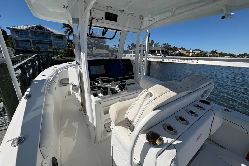 Slide: The Image of 2018 Sea Hunt Gamefish 30 boat with forward seating, docked by waterfront homes. - 9