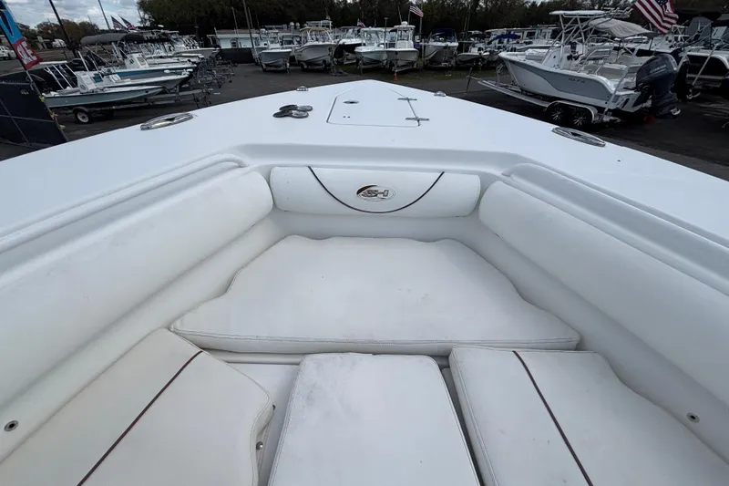 Slide: The Image of 2018 Sea Hunt Gamefish 30 Forward Seating, white cushioned bow area, in a boatyard. - 92