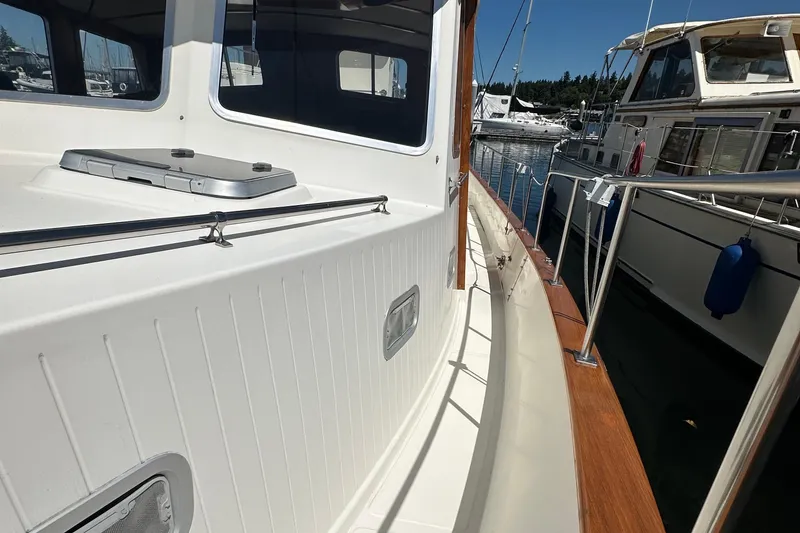 Slide: The Image of Eagle 40 Pilothouse Trawler 2000, docked, showcasing side deck and railing. - 16