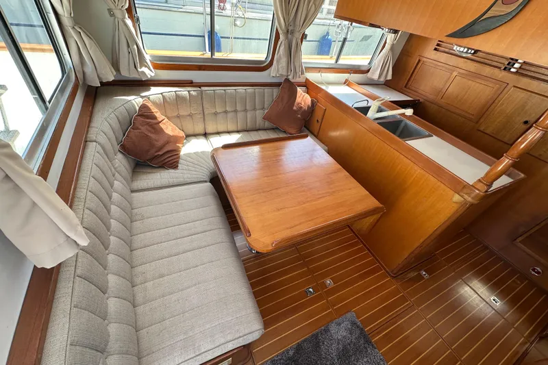 Slide: The Image of Interior of 2000 Eagle 40 Pilothouse Trawler with cozy seating and wooden table. - 19