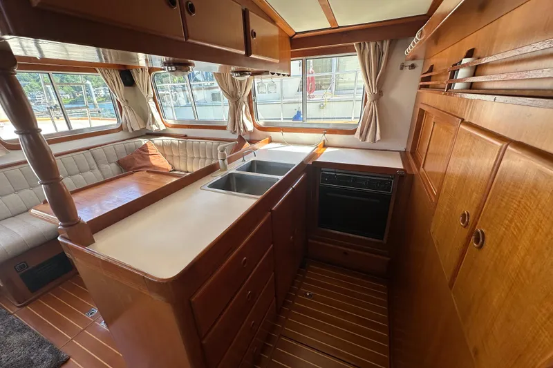 Slide: The Image of Interior of 2000 Eagle 40 Pilothouse Trawler with wood cabinetry and seating area. - 21