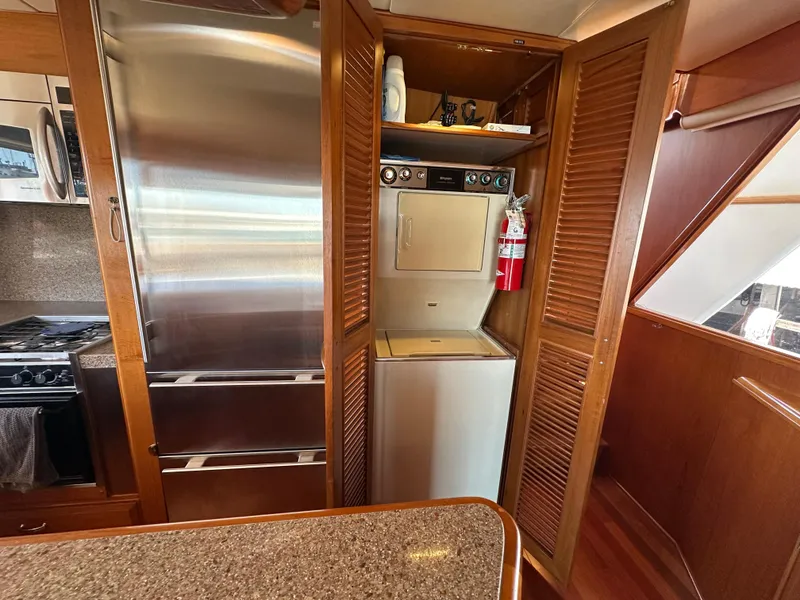 Slide: The Image of 1985 Ocean Alexander Pilothouse interior with stainless steel appliances and wooden cabinetry. - 48