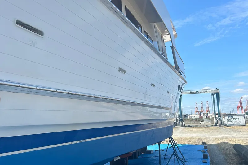 Slide: The Image of 1985 Ocean Alexander Pilothouse yacht on dry dock, side view with blue sky background. - 103