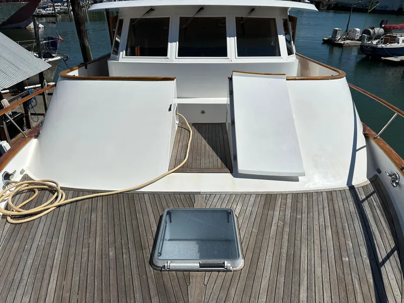 Slide: The Image of 1985 Ocean Alexander Pilothouse yacht deck with wooden flooring and white structures. - 17