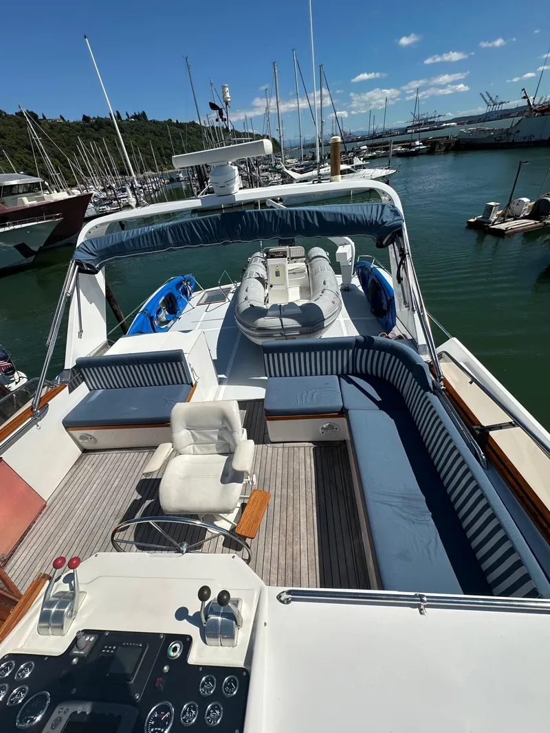 Slide: The Image of 1985 Ocean Alexander Pilothouse yacht with spacious deck and seating at marina. - 19