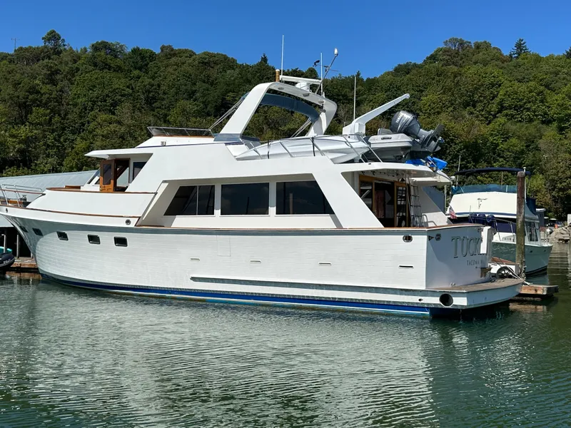 Slide: The Image of 1985 Ocean Alexander Pilothouse yacht docked in a serene marina setting. - 2