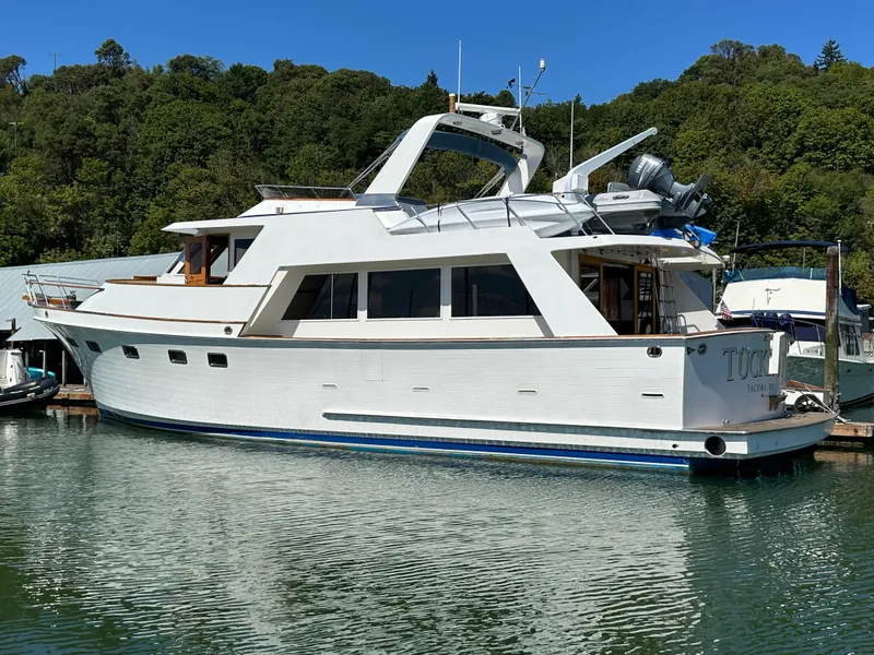 Slide: The Image of 1985 Ocean Alexander Pilothouse yacht docked in a serene marina setting. - 3