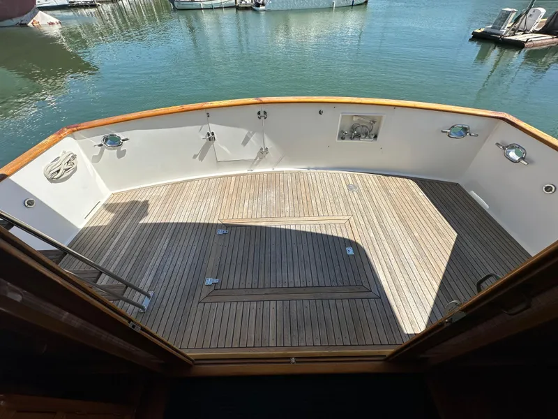 Slide: The Image of 1985 Ocean Alexander Pilothouse yacht deck with wooden flooring and marina view. - 31