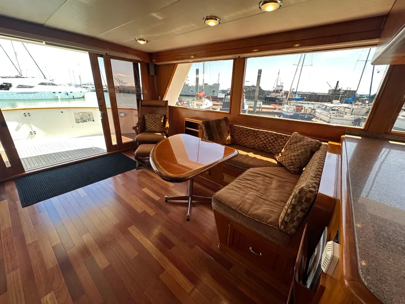Slide: The Image of Luxurious 1985 Ocean Alexander Pilothouse interior with wood flooring and marina view. - 36