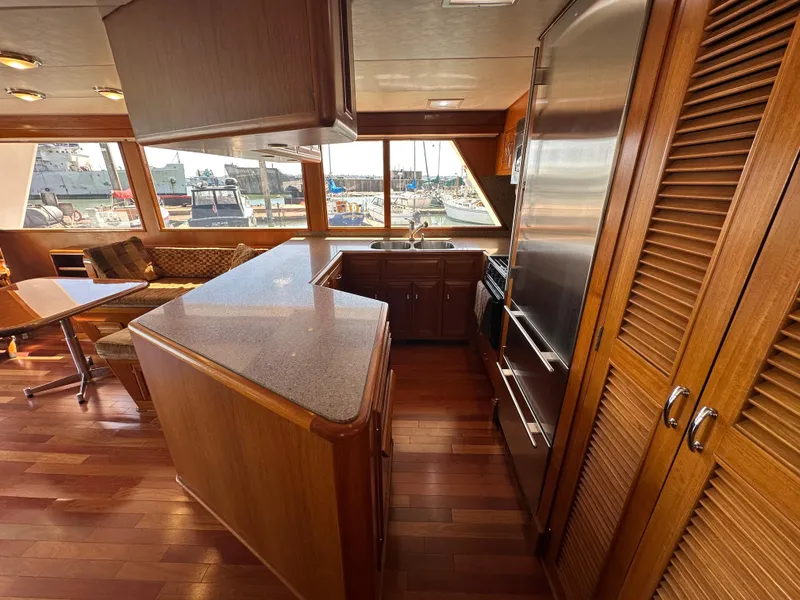 Slide: The Image of Luxurious 1985 Ocean Alexander Pilothouse interior with wood finishes and marina view. - 42