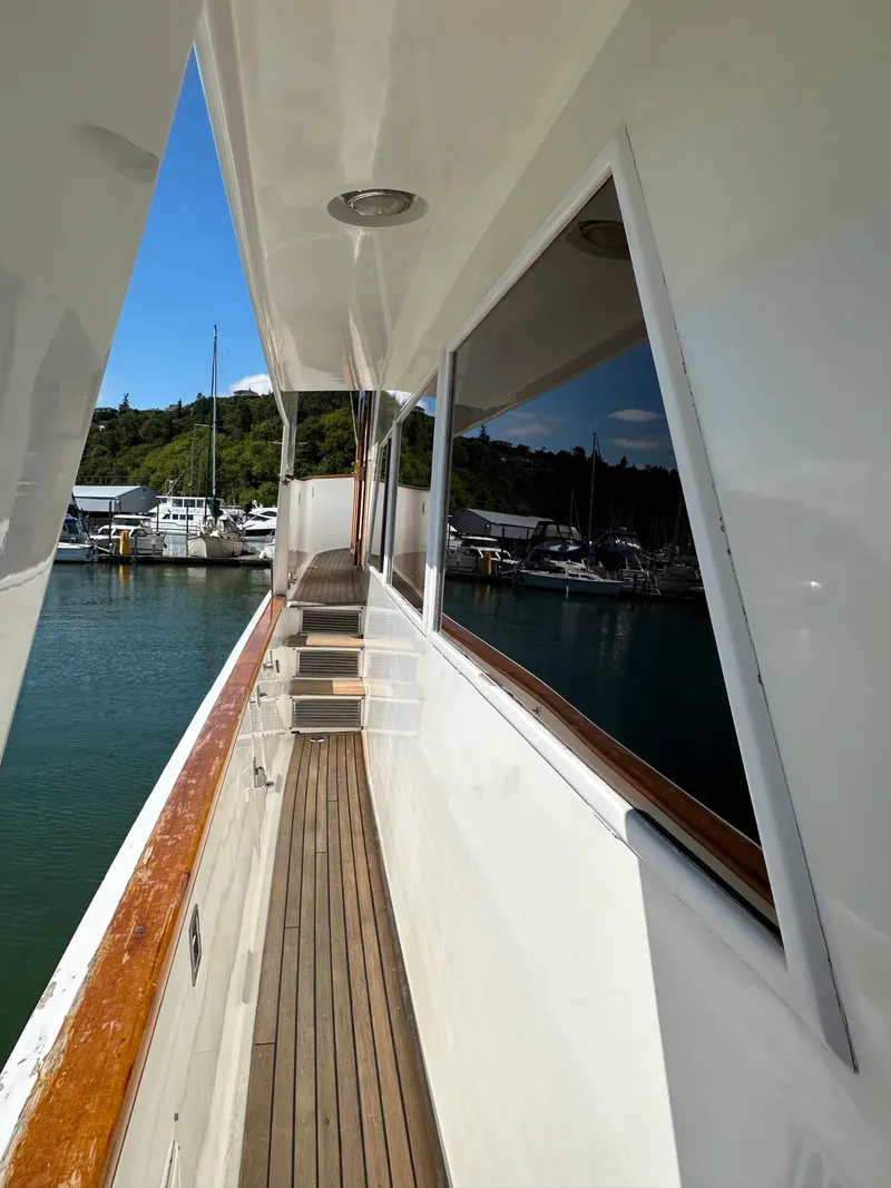 Slide: The Image of 1985 Ocean Alexander Pilothouse yacht deck with wooden trim, docked in a marina. - 9
