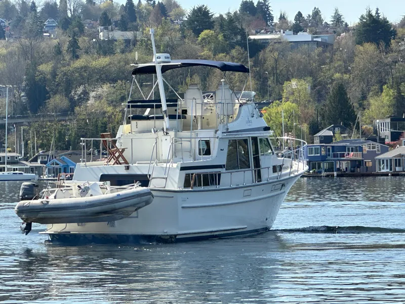 Slide: The Image of 1982 Tollycraft Tri Cabin boat cruising on a calm lake with scenic background. - 10