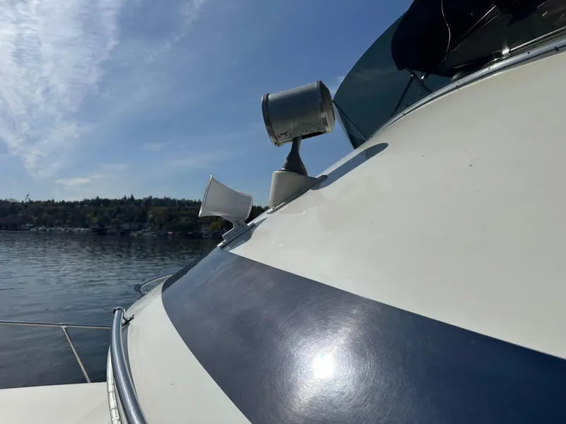 Slide: The Image of 1982 Tollycraft Tri Cabin boat with spotlight and horn on deck, under clear blue sky. - 16