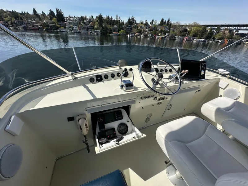 Slide: The Image of 1982 Tollycraft Tri Cabin helm with steering wheel, controls, and waterfront view. - 24