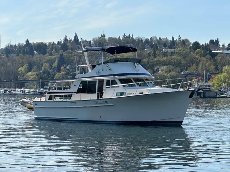 Slide: The Image of 1982 Tollycraft Tri Cabin yacht on a serene lake with a wooded shoreline. - 3