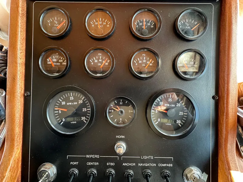 Slide: The Image of 1982 Tollycraft Tri Cabin dashboard with gauges and switches for navigation and control. - 32