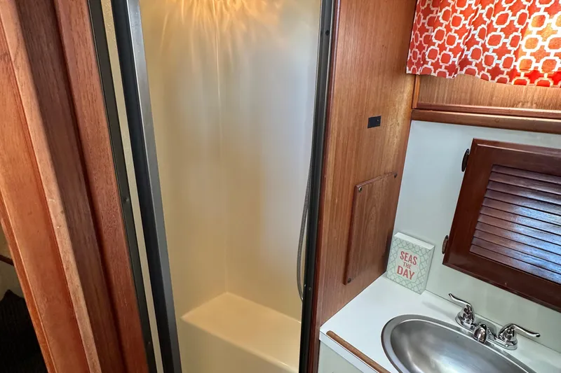 Slide: The Image of 1982 Tollycraft Tri Cabin bathroom with shower, sink, and nautical decor. - 43