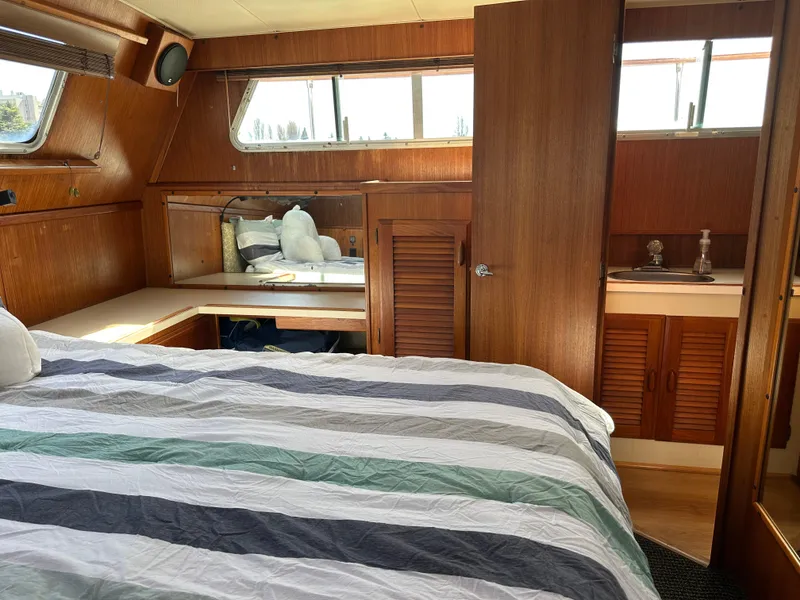 Slide: The Image of Interior of a 1982 Tollycraft Tri Cabin yacht with bed and wood paneling. - 49