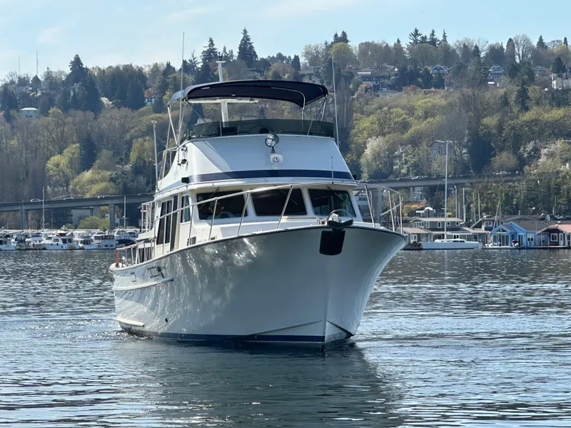 Slide: The Image of 1982 Tollycraft Tri Cabin yacht cruising on a calm lake with scenic forested hills. - 5