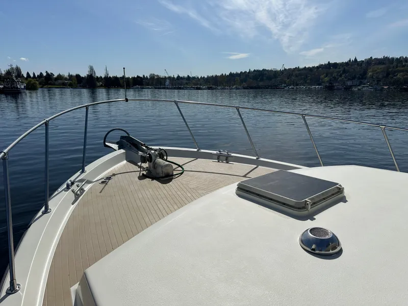 Slide: The Image of 1982 Tollycraft Tri Cabin boat on calm lake with clear sky and distant shoreline. - 17
