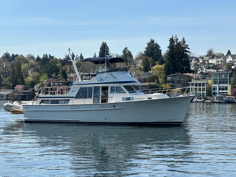 Slide: The Image of 1982 Tollycraft Tri Cabin yacht on calm water with scenic shoreline background. - 2