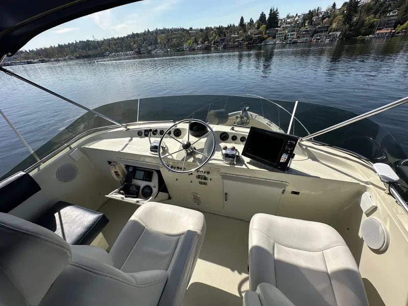 Slide: The Image of 1982 Tollycraft Tri Cabin helm with steering wheel, controls, and lake view. - 22