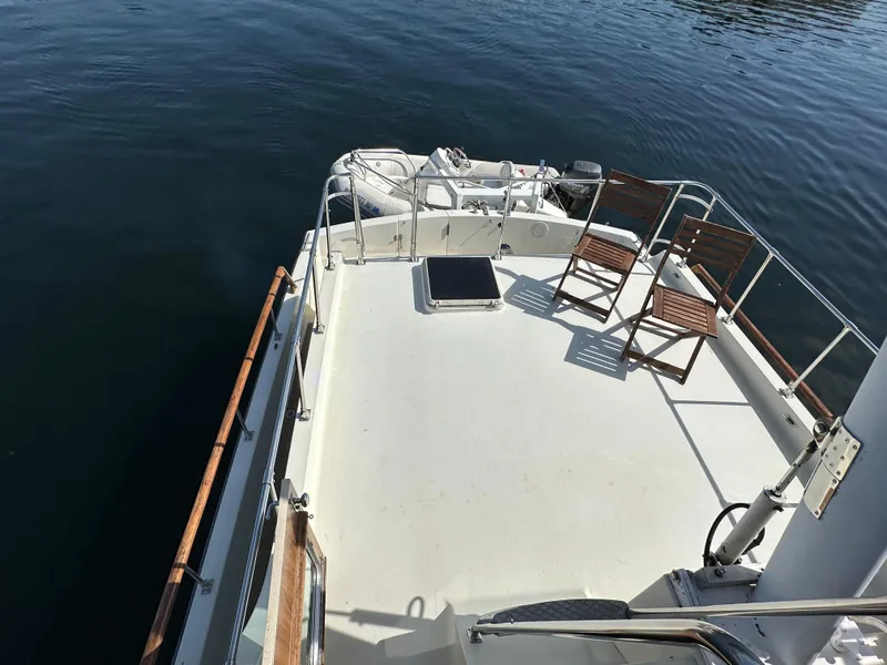 Slide: The Image of 1982 Tollycraft Tri Cabin boat deck with chairs, overlooking calm water. - 25