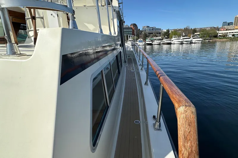 Slide: The Image of 1982 Tollycraft Tri Cabin yacht docked, showcasing side deck and marina view. - 26