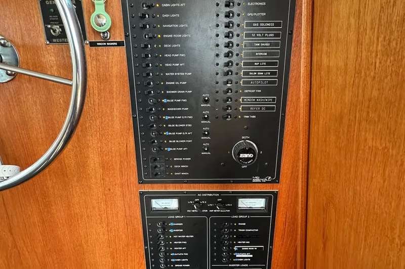 Slide: The Image of 1982 Tollycraft Tri Cabin control panel with switches and gauges on wooden background. - 33