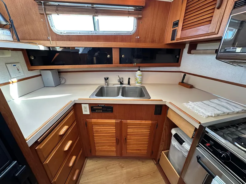 Slide: The Image of 1982 Tollycraft Tri Cabin kitchen with wooden cabinets, dual sink, and stove. - 38