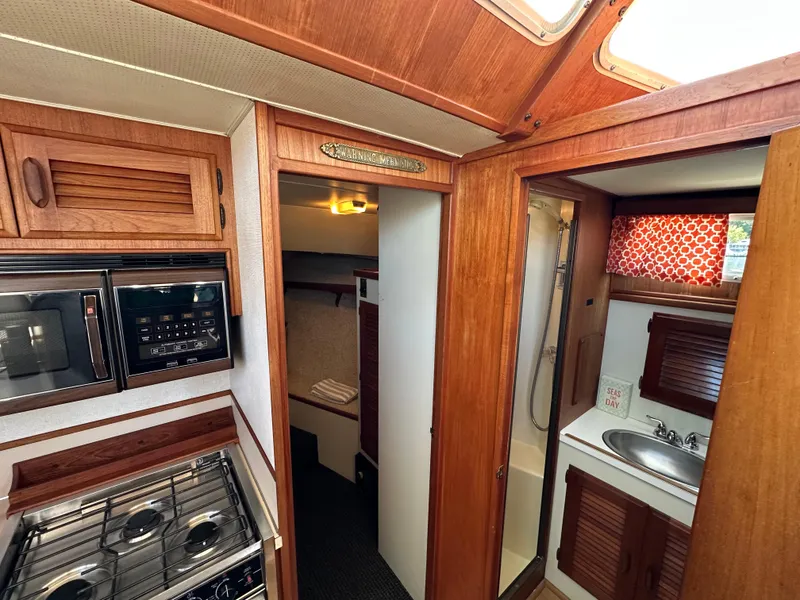 Slide: The Image of 1982 Tollycraft Tri Cabin interior with kitchen, bathroom, and wood paneling. - 44