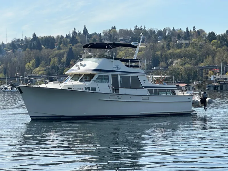 Slide: The Image of 1982 Tollycraft Tri Cabin yacht on calm water with scenic forested background. - 7