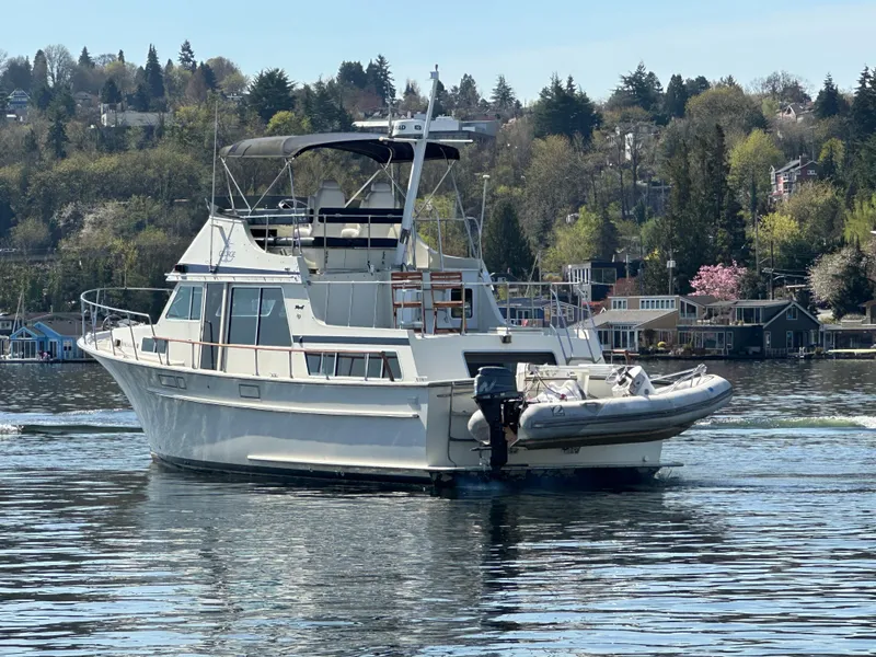 Slide: The Image of 1982 Tollycraft Tri Cabin yacht on a serene lake with scenic background. - 9