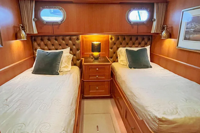 Slide: The Image of Luxurious twin cabin in 2001 Nordlund Enclosed Command Bridge yacht, featuring elegant wood paneling. - 21