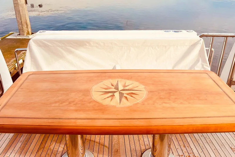 Slide: The Image of Wooden table with compass design on a 2001 Nordlund Enclosed Command Bridge yacht deck. - 24
