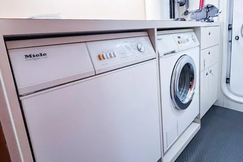 Slide: The Image of Laundry area with Miele appliances on a 2001 Nordlund Enclosed Command Bridge yacht. - 30