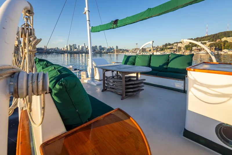 Slide: The Image of Luxurious 1931 Boeing Custom yacht deck with green seating, overlooking a serene waterfront cityscape. - 22