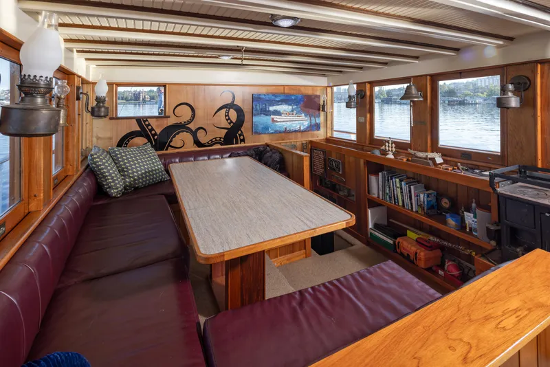Slide: The Image of Luxurious 1931 Boeing Custom boat interior with wood paneling, dining area, and scenic windows. - 39