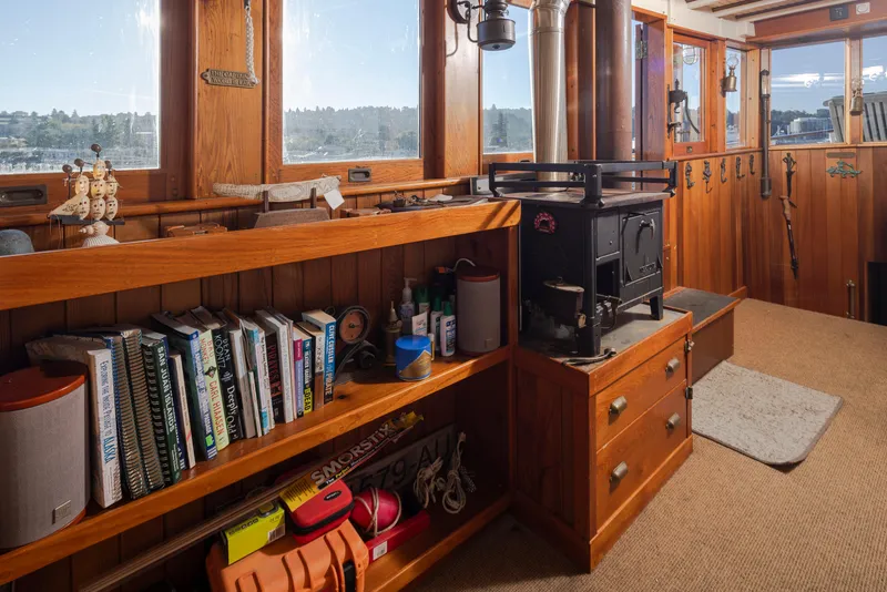 Slide: The Image of Interior of a 1931 Boeing Custom boat with wooden shelves, books, and a vintage stove. - 43